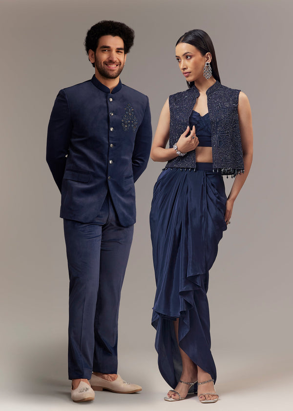 Contemporary Reception Couple Set – Navy Indo-Western Draped Skirt Set with Embroidered Jacket for Her And Blue Embroidered Bandhgala for Him