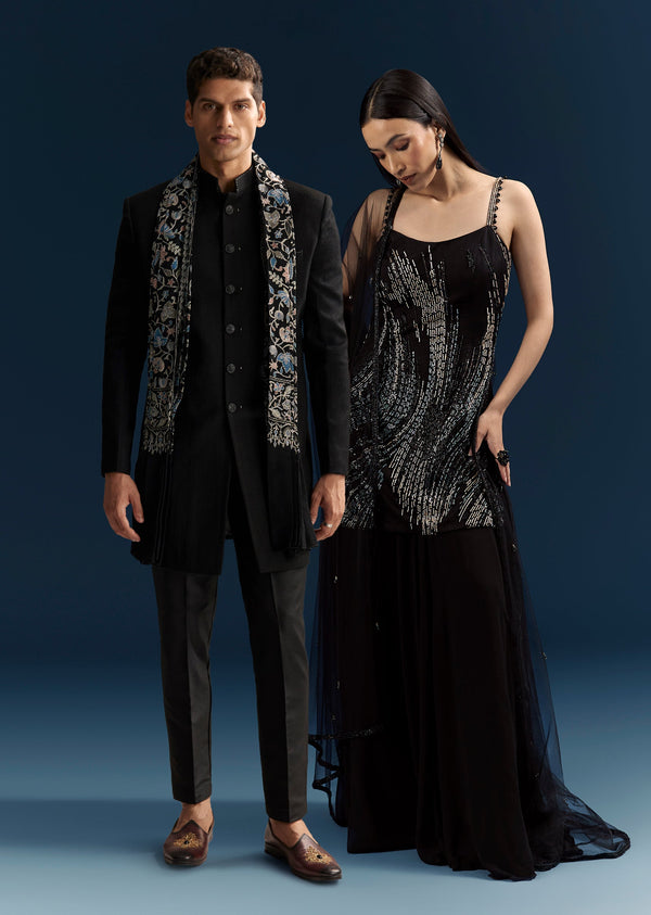 Black Tie Evening Glamour Couple Set – Black Sequins Sharara Suit with Cutdana Embroidery for Her And Black Jacquard Indo-Western Set with Embroidered Stole for Him