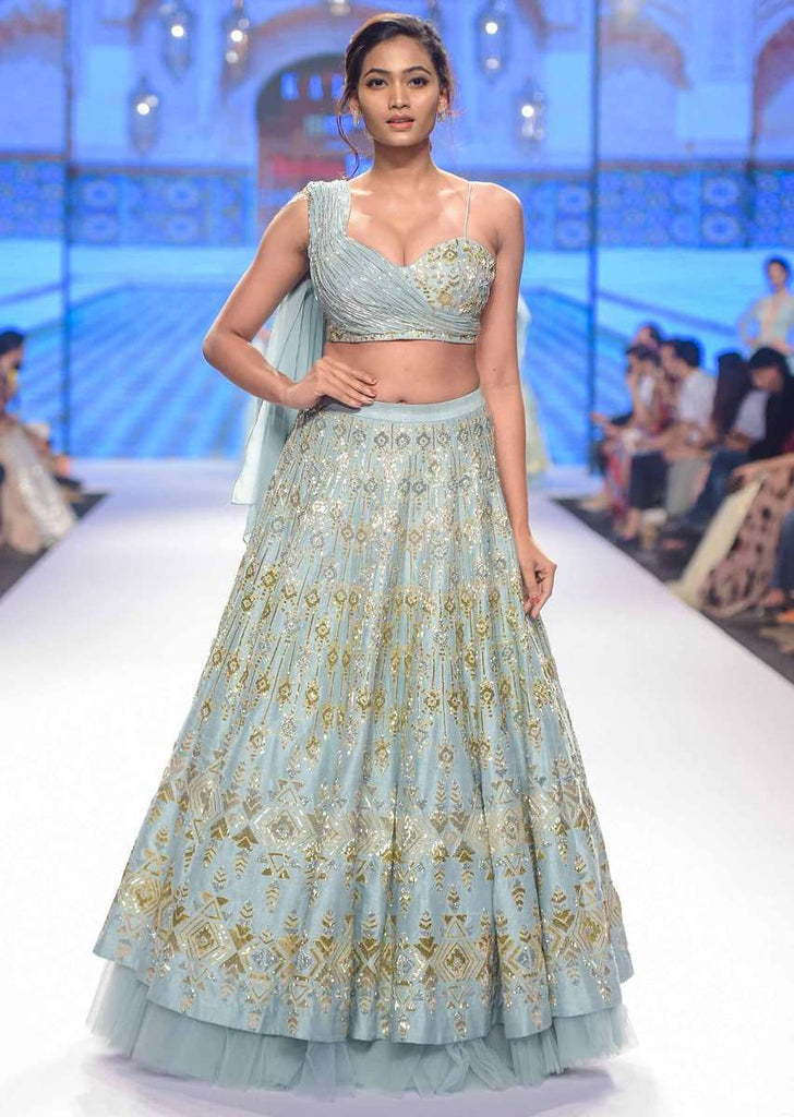 Aqua time blue raw silk lehenga teamed with one side strap bustier with georgette drape