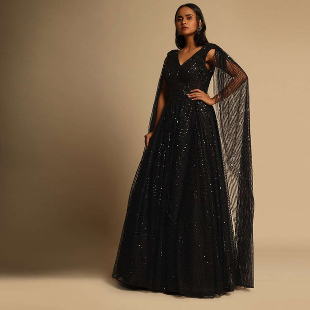 Black Gown In Sequins Embellished Net With Ruching In The Front, Sheer Sides And Net Cape On Each Shoulder