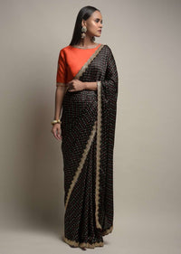 Black Saree In Satin Blend With Bandhani Print And Mirror Work Paired With Contrasting Coral Stitched Blouse