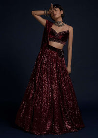 Burgundy Lehenga Embellished In Sequins With A Velvet Crop Top And Matching Belt Bag