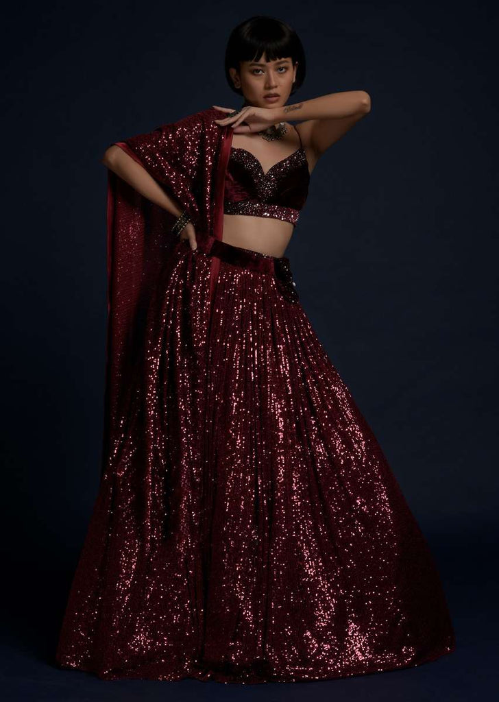 Burgundy Lehenga Embellished In Sequins With A Velvet Crop Top And Matching Belt Bag