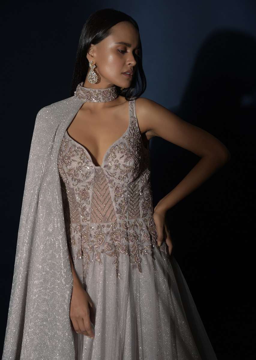 Champagne Embellished Gown With Plunging Neckline And A Fancy Choker With Attached Cape