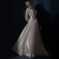 Champagne Gown In Crushed Shimmer With An Embellished Bodice Highlighting The Waistline And Fancy Cape
