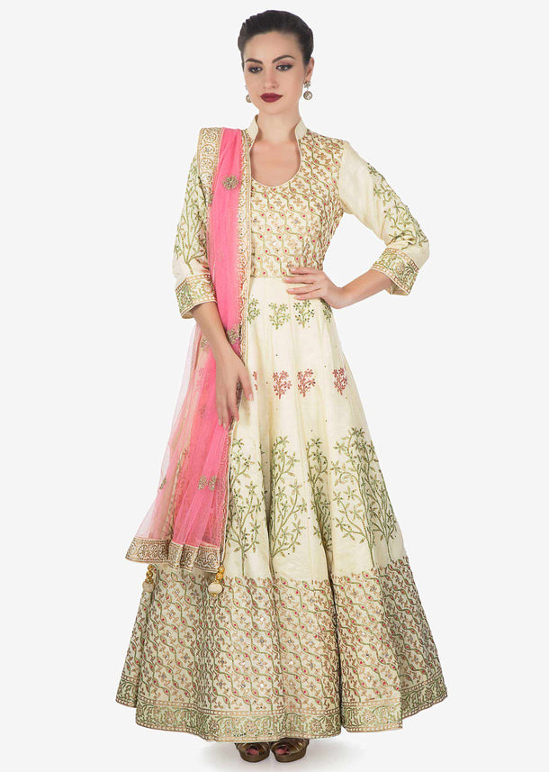 Cream cotton silk anarkali suit paired with pink net dupatta and lycra chudidar only on kalki