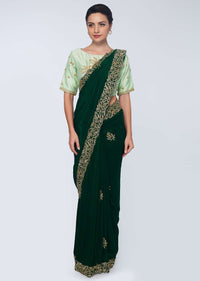 Emerald green satin saree embellished with cut dana embroidered butti and border