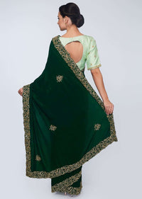 Emerald green satin saree embellished with cut dana embroidered butti and border