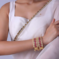 Gold Finish Bangles Embedded With Pearls And Red Meenakari Work (Set of 2)