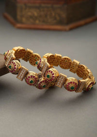 Gold Plated Kundan Bangles With Pink And Green Stones And Embossed Temple Work By Paisley Pop