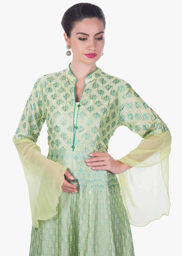 Light pista green suit featuring with foil printed butti and fancy buttons only on Kalki