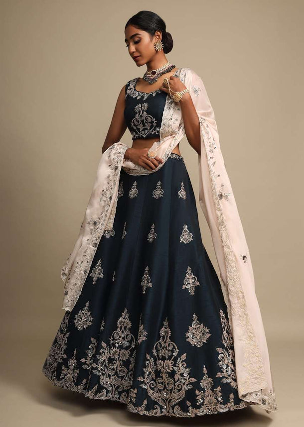 Midnight Teal Lehenga In Raw Silk With Zardozi Embroidered Floral Design On The Hem And Buttis Online - Kalki Fashion