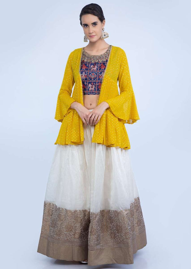 Off white floral brocade lehenga with navy blue batik printed crop top and yellow georgette jacket only on Kalki