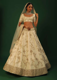 Off White Lehenga Choli In Raw Silk With Golden Cut Dana And Sequins Embroidered Floral Kalis And Geometric Border