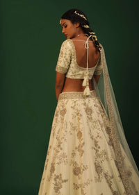 Off White Lehenga Choli In Raw Silk With Golden Cut Dana And Sequins Embroidered Floral Kalis And Geometric Border