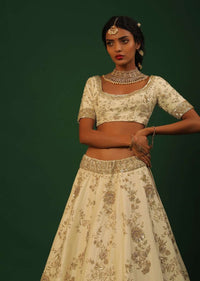 Off White Lehenga Choli In Raw Silk With Golden Cut Dana And Sequins Embroidered Floral Kalis And Geometric Border