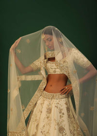 Off White Lehenga Choli In Raw Silk With Golden Cut Dana And Sequins Embroidered Floral Kalis And Geometric Border