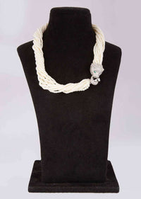 Off white multi string beaded necklace with animal motif pendant along with a matching tasseled earrings only on Kalki
