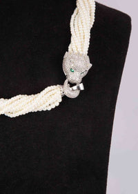 Off white multi string beaded necklace with animal motif pendant along with a matching tasseled earrings only on Kalki
