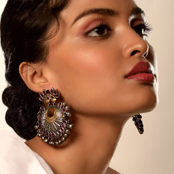 Oxydised Danglers With Carved Peacock Motif Along With Magenta Semi Precious Stones And Ghungru Tassels