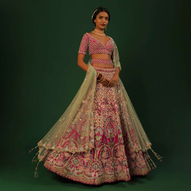 Rani Pink Lehenga Choli In Raw Silk With Heavy Embroidered Kalis Using Colorful Resham And Cut Dana In Floral Motifs Online - Kalki Fashion