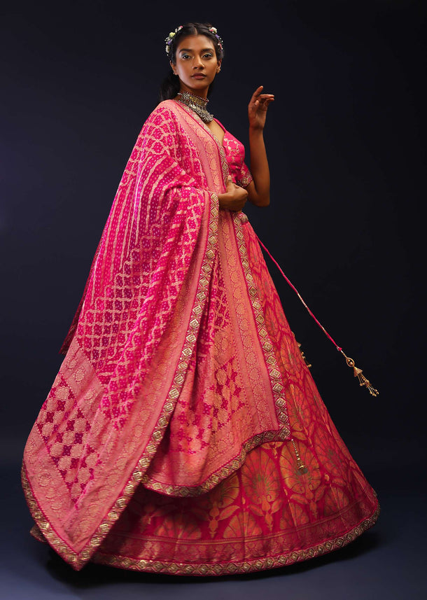 Rani Pink Lehenga Choli With Golden And Multi Colored Woven Floral Kalis And Bandhani Dupatta