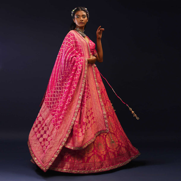 Rani Pink Lehenga Choli With Golden And Multi Colored Woven Floral Kalis And Bandhani Dupatta