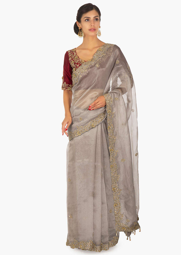 Red raw silk embellished blouse  paired with grey organza saree