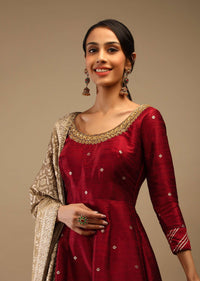 Ruby Wine Anarkali Suit In Raw Silk With Brocade Buttis, Zardosi Embroidered Neckline And Contrasting Gold Brocade Dupatta