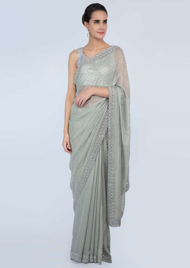 Sage green shimmer georgette saree adorn with moti scattered and heavy stone embroidered border only on Kalki