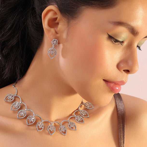 Silver Necklace And Earrings With Flower-In-A-Leaf Design Embedded With White Stones