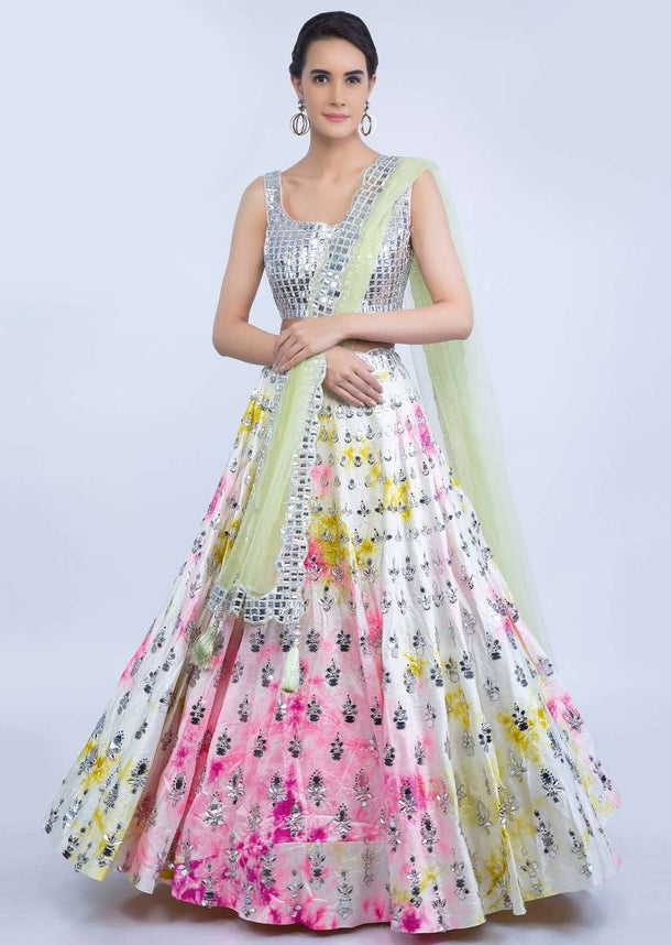 White raw silk tye and tye lehenga with silver beaded blouse and green net dupatta only on Kalki