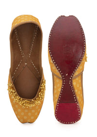 Yellow Print Juttis In Silk With Ghungroo Embellishment And Geometric Print